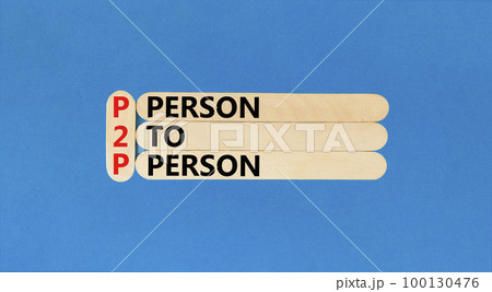 P2P person to person symbol. Concept words P2P person to person on wooden stick on a beautiful blue table blue background. Business and P2P person to person concept. Copy space. 100130476