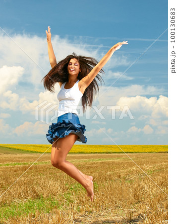 Im free. Shot of a beautiful young woman in the countryside with her arms outstretched in joy. 100130683