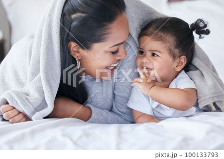 Mother, child and baby playing with woman bonding in a bed with blanket laughing being funny together in a bedroom or room. Mom, kid and single parent in a home or house with little daughter Mother, child and baby playing with woman bonding in a bed with blanket laughing being funny together in a bedroom or room. Mom, kid and single parent in a home or house with little daughter 100133793