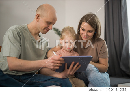 Deaf child girl with cochlear implant studying to hear sounds and have fun with mother and father - recovery after cochlear Implant surgery and rehabilitation concept Deaf child girl with cochlear implant studying to hear sounds and have fun with mother and father - recovery after cochlear Implant surgery and rehabilitation concept 100134231