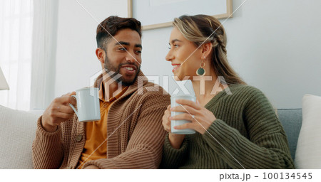 Movie, coffee and couple watching tv or streaming an online series via a subscription for fun entertainment at home. Relaxing, smile and happy woman enjoying a film together on a sofa with partner 100134545
