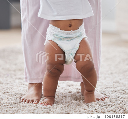 Baby legs, learning and walking with mother, support and first steps of healthy body development. Closeup mom teaching child to walk, balance and feet on carpet for growth, milestone and motor skills Baby legs, learning and walking with mother, support and first steps of healthy body development. Closeup mom teaching child to walk, balance and feet on carpet for growth, milestone and motor skills 100136817