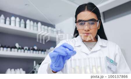 Young female scientists doing tube testing in a modern laboratory. Micro biologist examine liquid bacteria in glassware mixture to invent a vaccine cure for virus at innovative research hospital 100137866