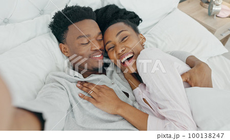 Selfie influencer couple in bed and portrait smile for fun indoor weekend or waking up together in the morning. Fun, happy black people in bedroom and a POV portrait photo for social media content Selfie influencer couple in bed and portrait smile for fun indoor weekend or waking up together in the morning. Fun, happy black people in bedroom and a POV portrait photo for social media content 100138247