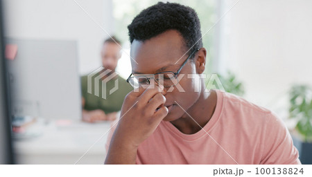 Stress, anxiety and mental health with a business black man removing his glasses while suffering from a headache at work. Burnout, frustration and migraine with a male employee working in his office 100138824