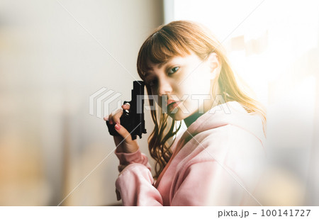 銃を構えた女性の映画のようなワンシーン 銃を構えた女性の映画のようなワンシーン 100141727