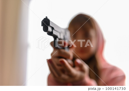 銃を構えた女性の映画のようなワンシーン 100141730