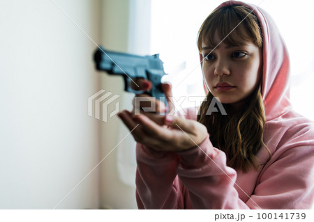 銃を構えた女性の映画のようなワンシーン 100141739