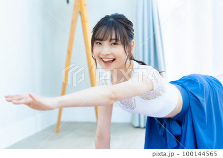 明るいリビングでヨガをする若い女性 明るいリビングでヨガをする若い女性 100144565