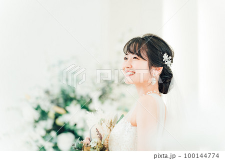 結婚式場でブーケを持つ花嫁・新婦の女性(横顔) 結婚式場でブーケを持つ花嫁・新婦の女性(横顔) 100144774