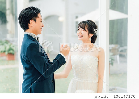 結婚式でファーストバイトをする新郎新婦(ウェディングケーキ・ケーキ入刀) 100147170