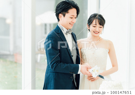 結婚式でケーキ入刀をする新郎新婦(ウェディングケーキ・ケーキカット) 結婚式でケーキ入刀をする新郎新婦(ウェディングケーキ・ケーキカット) 100147651