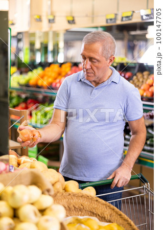 man buy large onion in supermarket man buy large onion in supermarket 100147705