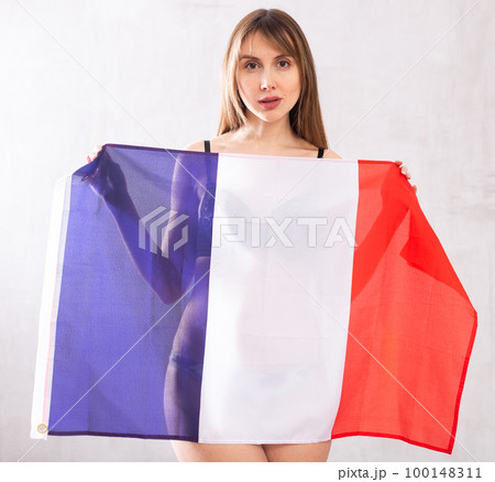 Young woman holding flag of French with a happy face and smiling Young woman holding flag of French with a happy face and smiling 100148311