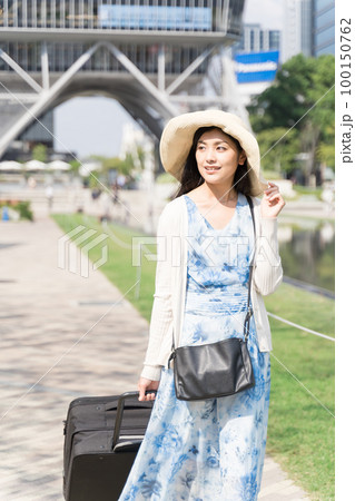 スーツケースを引いて名古屋観光をする若い女性 スーツケースを引いて名古屋観光をする若い女性 100150762