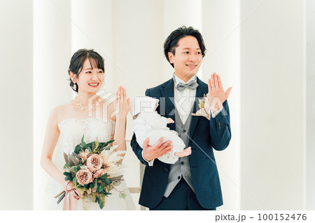 結婚式場で赤ちゃんと一緒に結婚式をあげる新郎新婦(指輪交換・授かり婚・おめでた婚・パパママ婚) 結婚式場で赤ちゃんと一緒に結婚式をあげる新郎新婦(指輪交換・授かり婚・おめでた婚・パパママ婚) 100152476