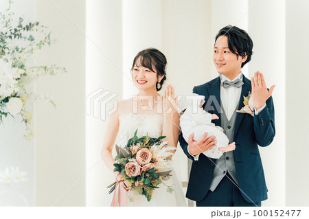 結婚式場で赤ちゃんと一緒に結婚式をあげる新郎新婦(指輪交換・授かり婚・おめでた婚・パパママ婚) 結婚式場で赤ちゃんと一緒に結婚式をあげる新郎新婦(指輪交換・授かり婚・おめでた婚・パパママ婚) 100152477