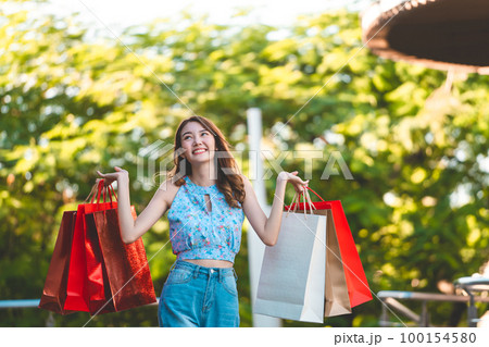 Happy young adult southeast asian woman with shopping bags on day Happy young adult southeast asian woman with shopping bags on day 100154580