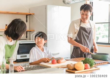 家のキッチンで子供と一緒に料理・クッキングする夫婦・親子・家族・男女 100156409