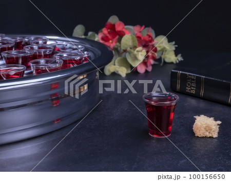 Taking communion the wine and the bread symbols on black background Taking communion the wine and the bread symbols on black background 100156650