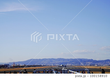 大阪　豊中　千里川の土手と大阪国際空港の離陸飛行機（原田進入灯橋付近から、晩冬） 100158910