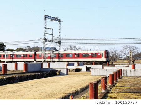 世界遺産平城宮跡内の復元遺跡横を駆け抜ける近鉄奈良線の電車 世界遺産平城宮跡内の復元遺跡横を駆け抜ける近鉄奈良線の電車 100159757