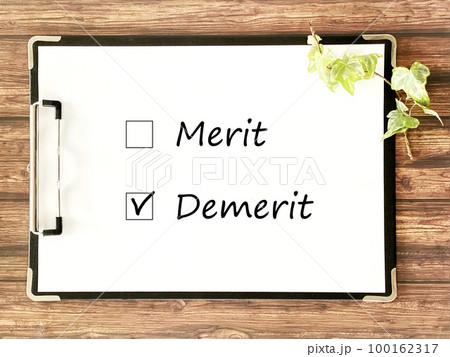 クリップボードに挟んだ白い用紙_茶色木板背景_横_MeritとDemeritの文字入り2 クリップボードに挟んだ白い用紙_茶色木板背景_横_MeritとDemeritの文字入り2 100162317