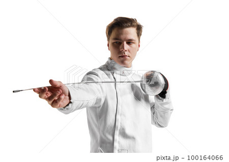 Young man, male fencer in fencing costume mask standing with sword over white studio background. Sport, motivation, professional skills 100164066