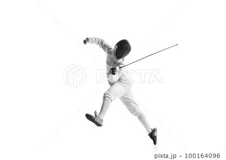 Professional male fencer in fencing costume training with sword isolated on white studio background. Concept of sport, competition, professional skills, achievements 100164096