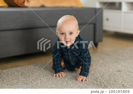 Nursery baby boy crawling on floor indoors at home copy space and empty space for text - Baby curiosity and child development stages Nursery baby boy crawling on floor indoors at home copy space and empty space for text - Baby curiosity and child development stages 100165809
