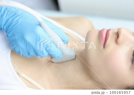 Scanning the thyroid gland of woman in medical clinic closeup Scanning the thyroid gland of woman in medical clinic closeup 100165957