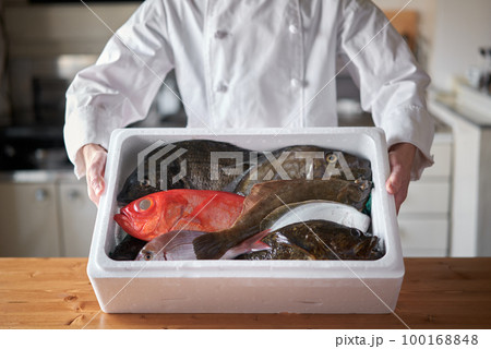 産地から届いた鮮魚を持つシェフ 100168848