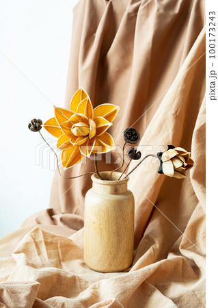 Dried flowers in wooden vase against draper. Monochromatic modern still life. Dried flowers in wooden vase against draper. Monochromatic modern still life. 100173243