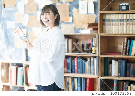 お気に入りの本を読む若い女性 100173358