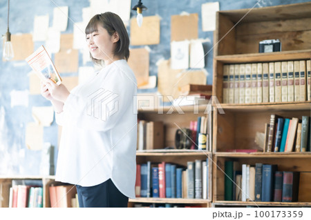 お気に入りの本を読む若い女性 お気に入りの本を読む若い女性 100173359