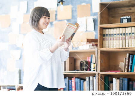 お気に入りの本を読む若い女性 お気に入りの本を読む若い女性 100173360