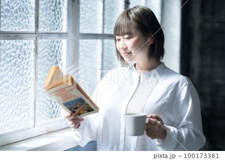 お気に入りの本を読む若い女性 お気に入りの本を読む若い女性 100173361