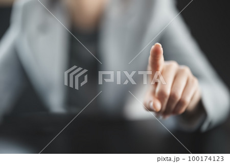 Businesswoman sitting at the black table and pointing by finger. Businesswoman sitting at the black table and pointing by finger. 100174123