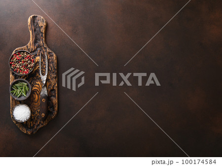 Chopping board with salt,pepper and rosemary with barbeque steel fork on brown Chopping board with salt,pepper and rosemary with barbeque steel fork on brown 100174584