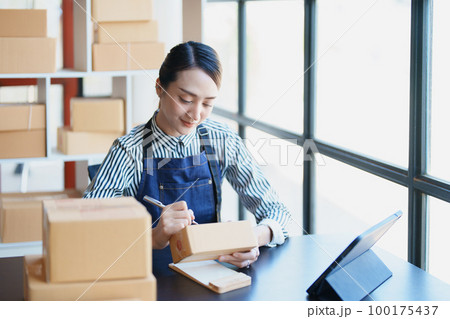 Starting small business entrepreneur of independent Asian female online seller packing products to send to customers and SME delivery concept. Starting small business entrepreneur of independent Asian female online seller packing products to send to customers and SME delivery concept. 100175437