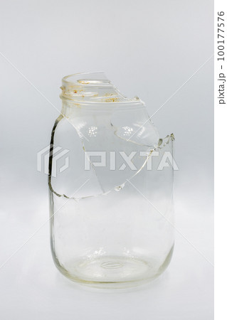 Broken glass jar closeup on white 100177576