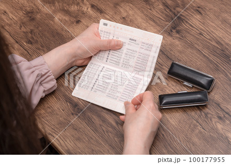 【預金通帳を見る主婦 印鑑あり】 【預金通帳を見る主婦 印鑑あり】 100177955