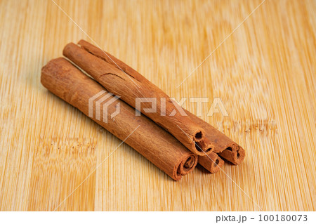 Cinnamon sticks on a wooden background. Fragrant cinnamon seasoning close-up. Spices with cinnamon. Food cooking video concept. ingredients for warm wine, mulled wine 100180073