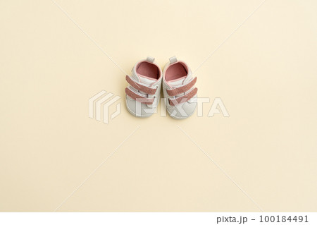 Baby pink shoes on yellow paper background with copy space. Baby clothes concept. Top view, flat lay 100184491