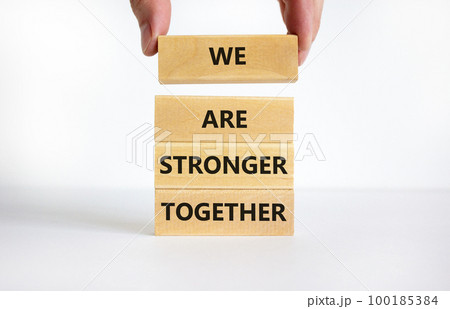 We are stronger together symbol. Concept words We are stronger together on wooden blocks. Businessman hand. Beautiful white background, copy space. Business and we are stronger together concept. 100185384