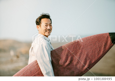 サーフィンを楽しむ50代の日本人男性 100188495