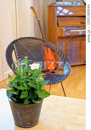 Guitar, chair and a piano in the background 100190044