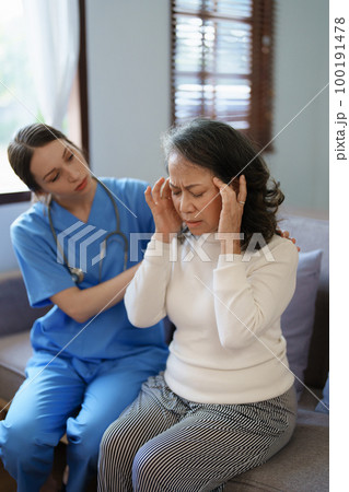 Portrait of a female doctor talking to an elderly patient showing headache Portrait of a female doctor talking to an elderly patient showing headache 100191478