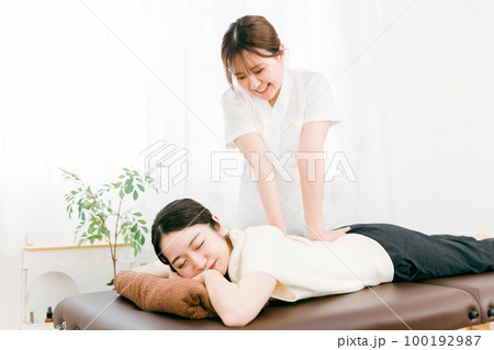 整骨院で腰を揉む整体師・マッサージ師・セラピストの女性（腰痛） 100192987