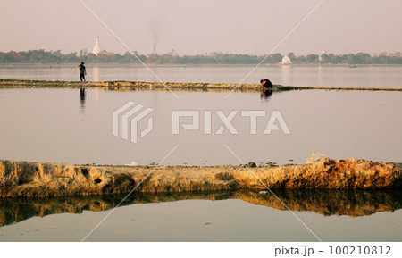 Fisherman working on the lake in early morning 100210812